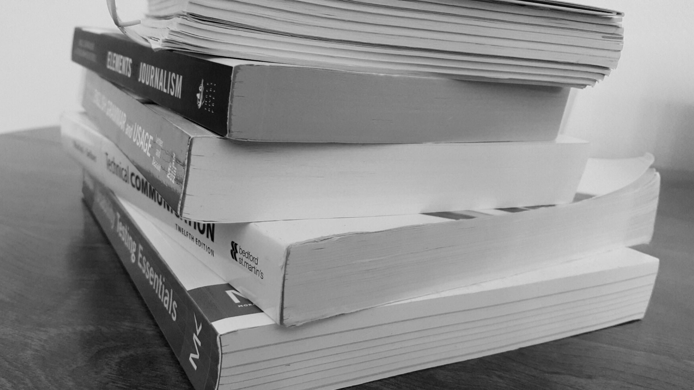 black and white stack of textbooks, side view
